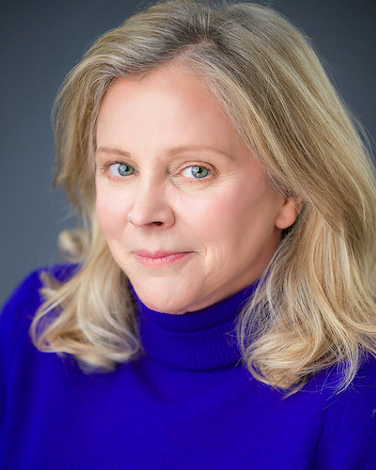 Headshot of Julie Austin, inventor and founder of Swiggies, in a blue turtleneck.